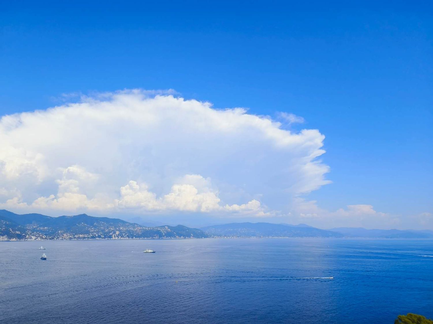海湾上方如棉花糖般耸立的巨大积雨云与远山